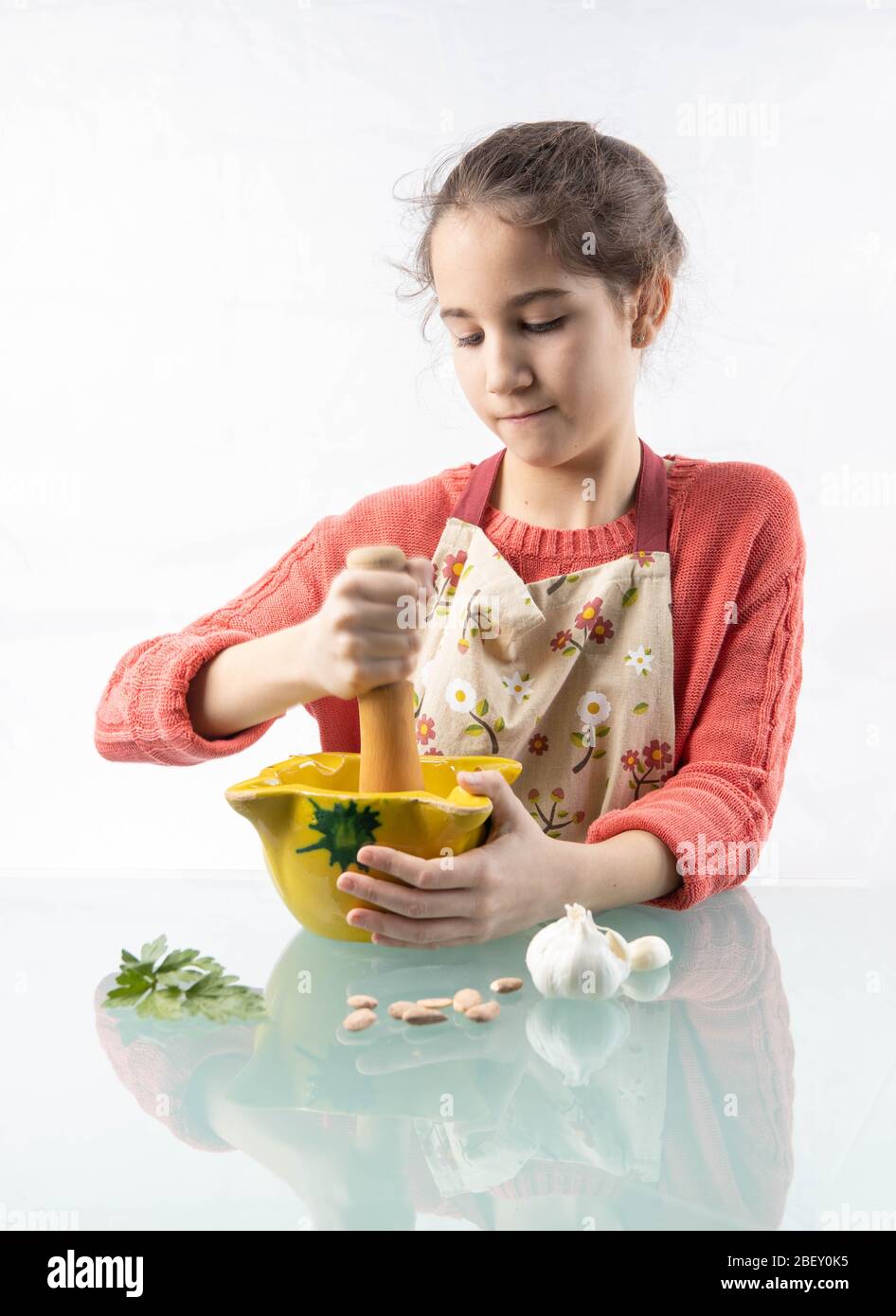 Niña préparado con el mortero una receta de cocina con fondo blanco Banque D'Images