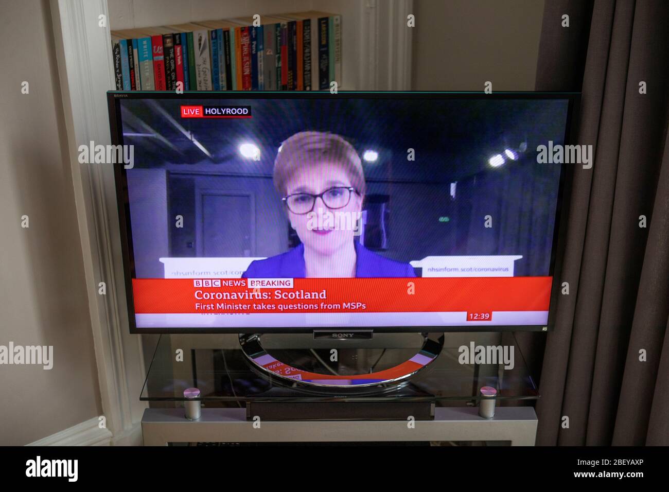 La première ministre d'Écosse Nicola Sturgeon est diffusée à la télévision dans un salon d'Édimbourg lors de la diffusion d'une séance « virtuelle » des questions du Premier ministre, où les dirigeants de tous les partis d'opposition ont la possibilité de la remettre en question à distance, leur permettant d'examiner la réponse du gouvernement à la crise du coronavirus (COVID-19). Banque D'Images