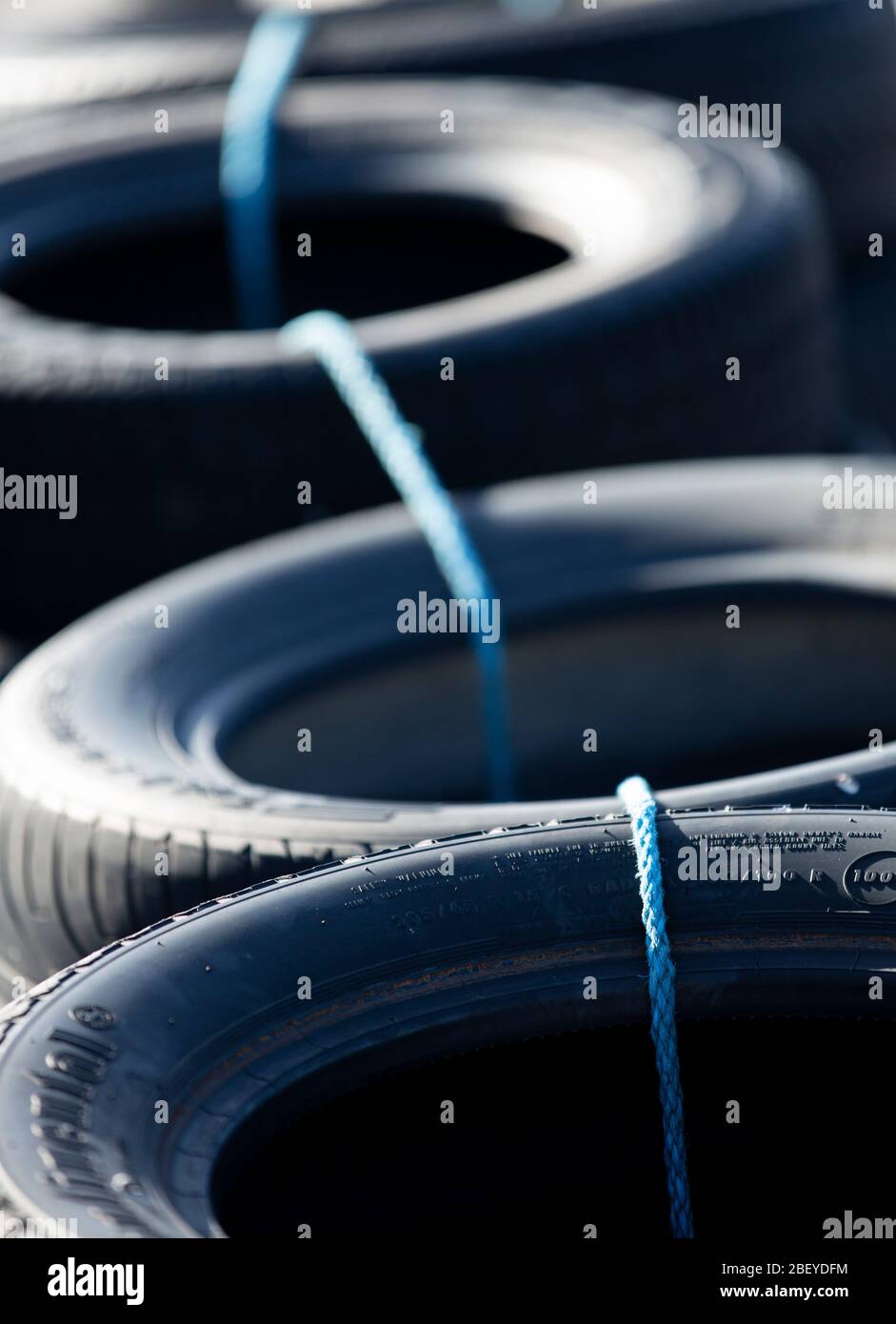Gros plan des pneus de voiture attachés avec la corde , formant une barrière de pneu sur la piste de course Banque D'Images