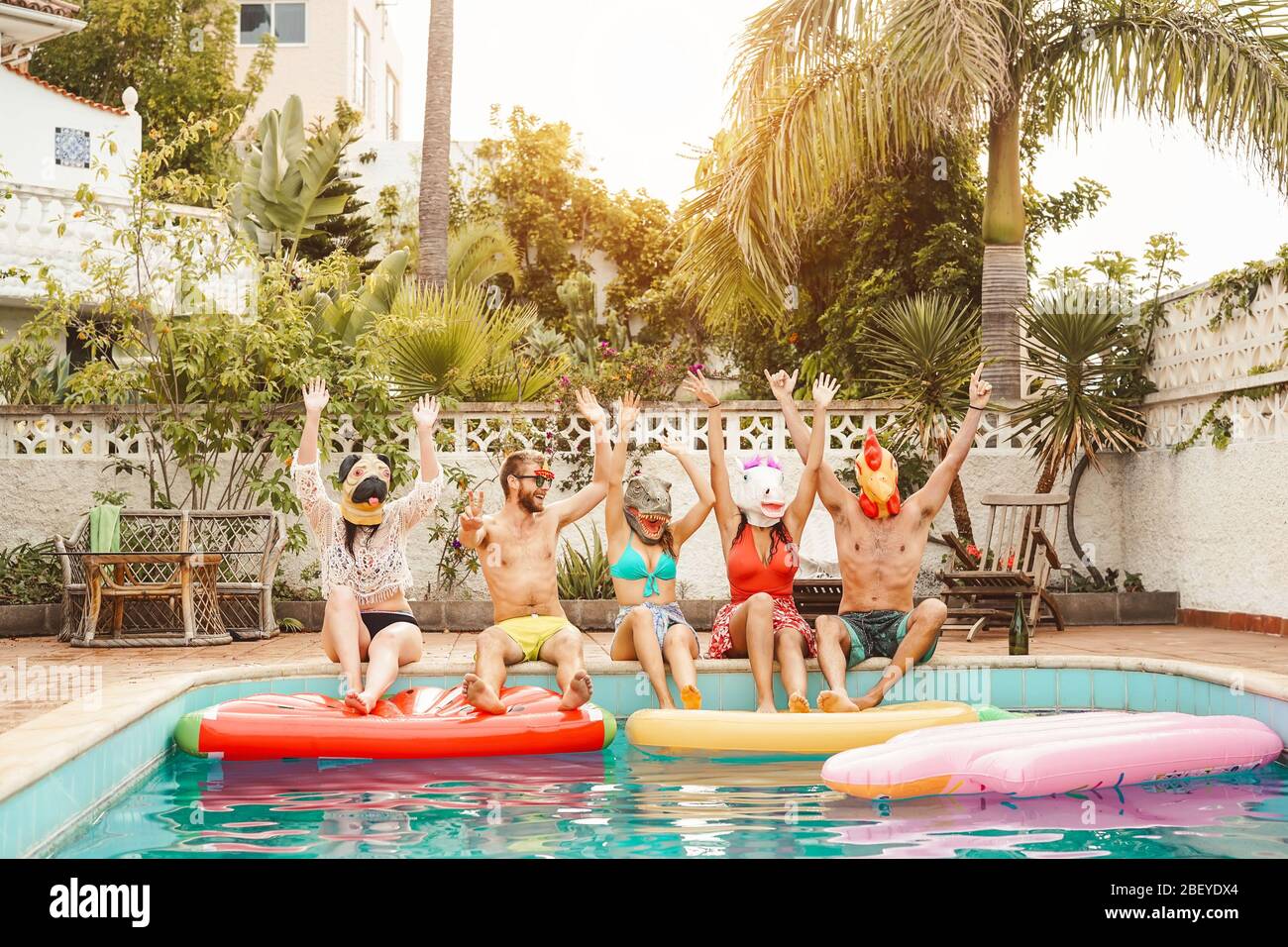 Groupe heureux amis faisant la fête de la piscine - jeunes ayant plaisir à célébrer l'événement de carnaval dans la piscine exclusive vacances tropicales d'été Banque D'Images