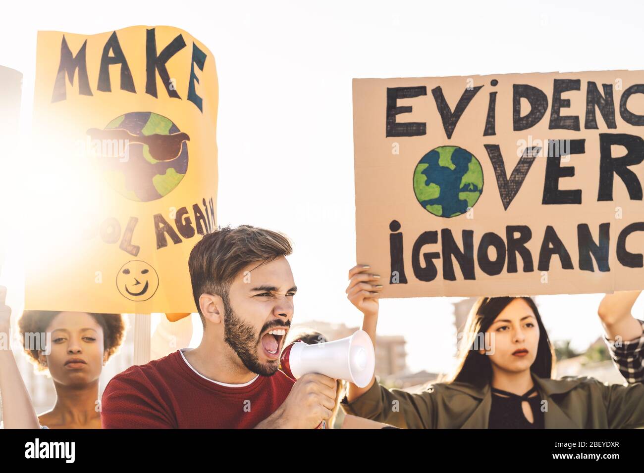 Des manifestants de groupe protestent contre la pollution plastique et le changement climatique - des personnes Multiraciales se battent sur la route et détiennent des bannières Banque D'Images