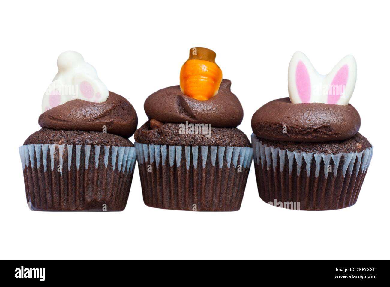 M&S Cupcakes de Pâques isolés sur fond blanc - trois mini-cupcakes au chocolat avec crème au beurre de chocolat et décorations de Pâques Banque D'Images