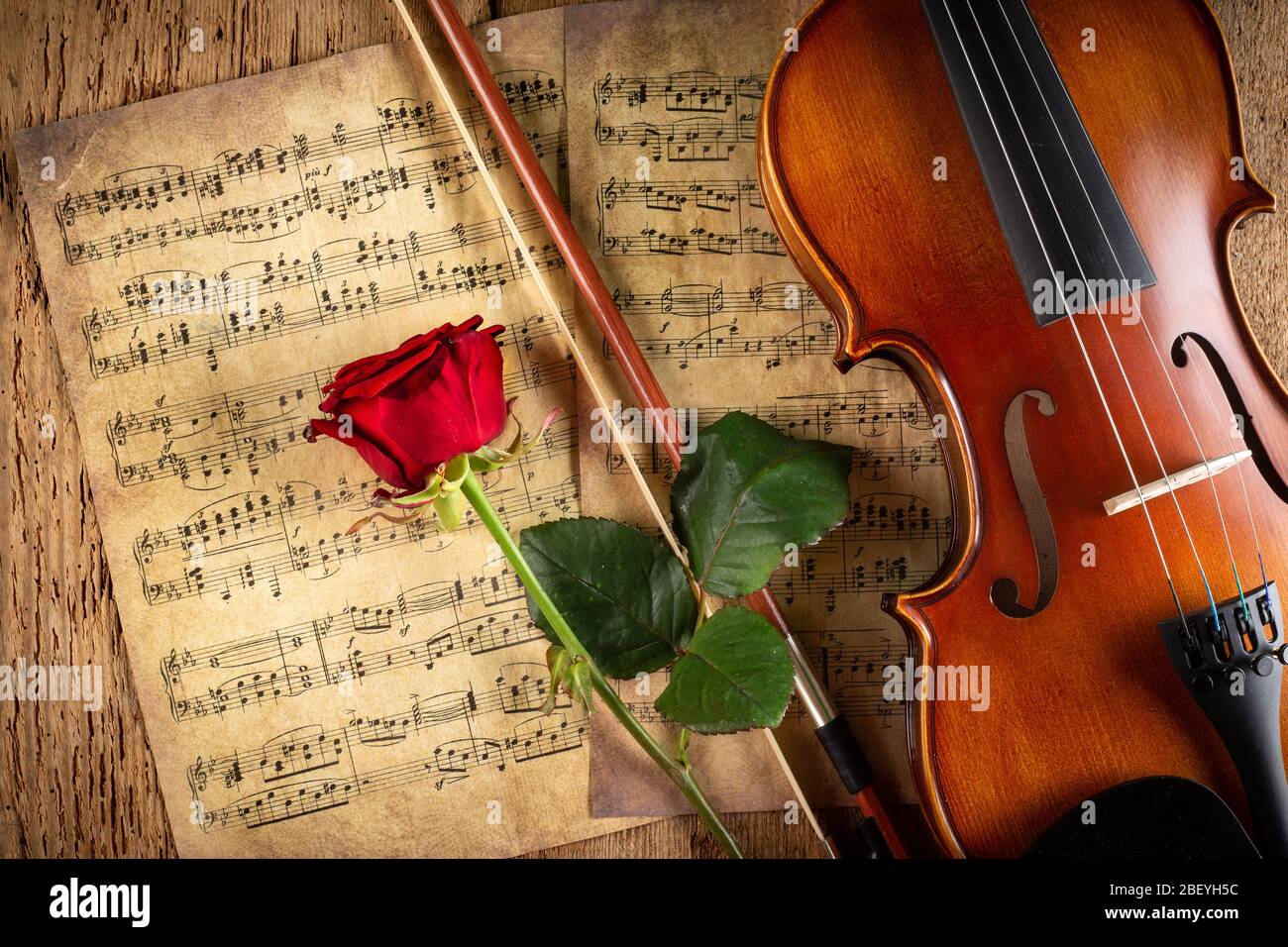 musique classique rétro pour violon chaîne instrutt sur la vieille musique  note papier avec fleur de rose rouge sur fond de bois de chêne ancien. musique  classique rom Photo Stock - Alamy
