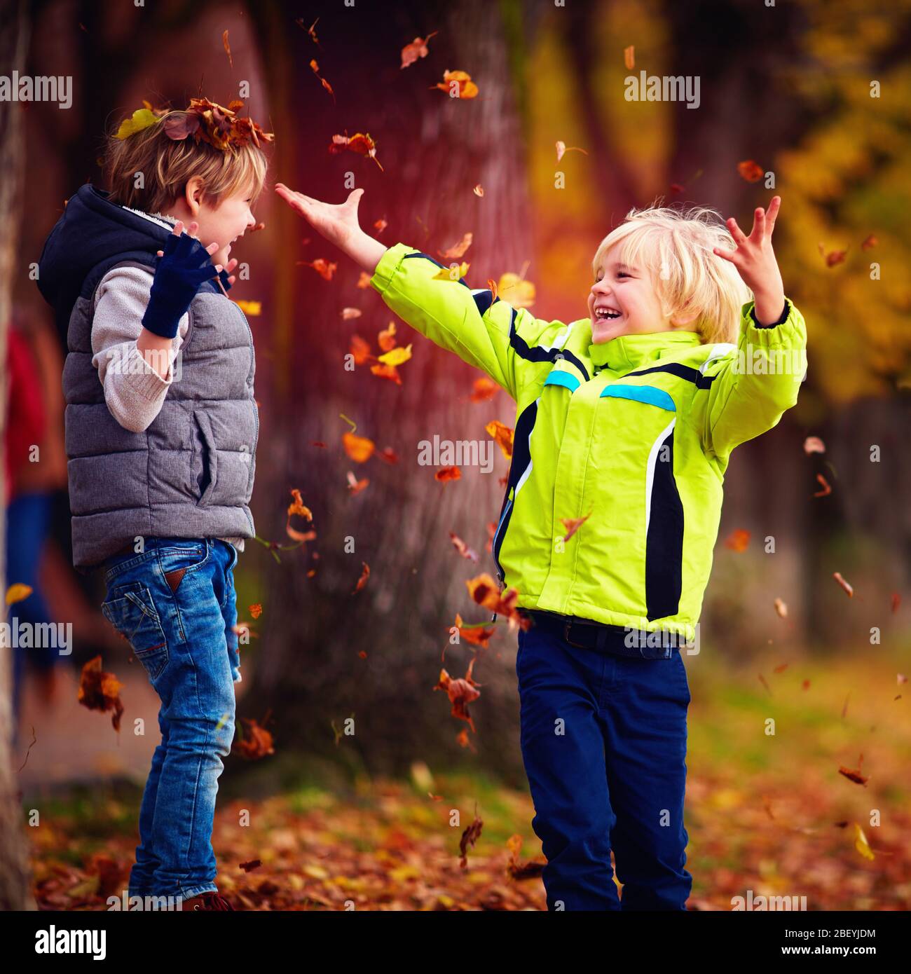 les enfants de l'école enchantés qui ont lancé des jets de joie ont quitté le parc d'automne Banque D'Images