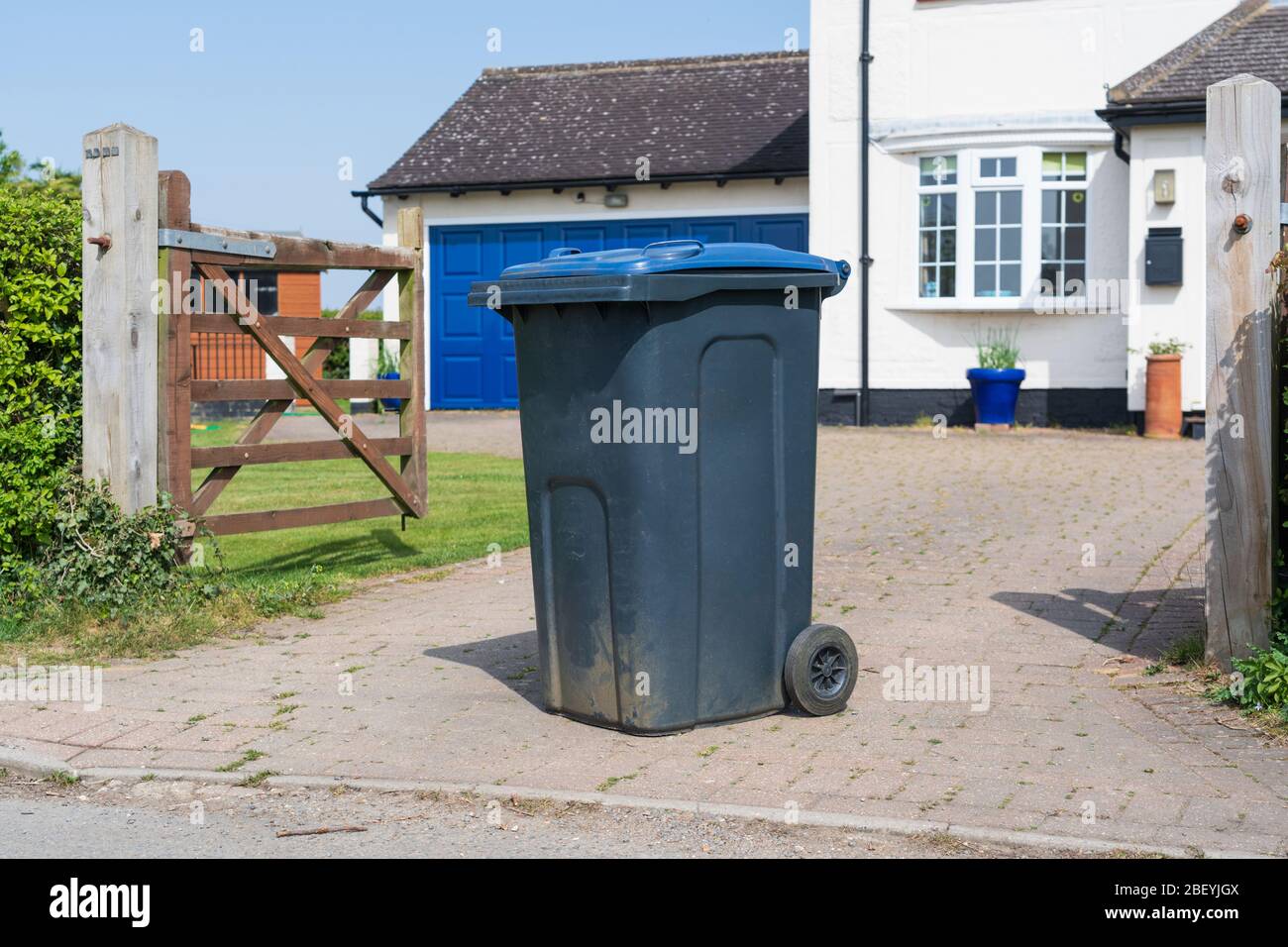 Bac à roue simple avec couvercle bleu à l'extérieur de la maison prêt à être vidé par les collecteurs de déchets. Beaucoup Hadham, Hertfordshire. ROYAUME-UNI Banque D'Images