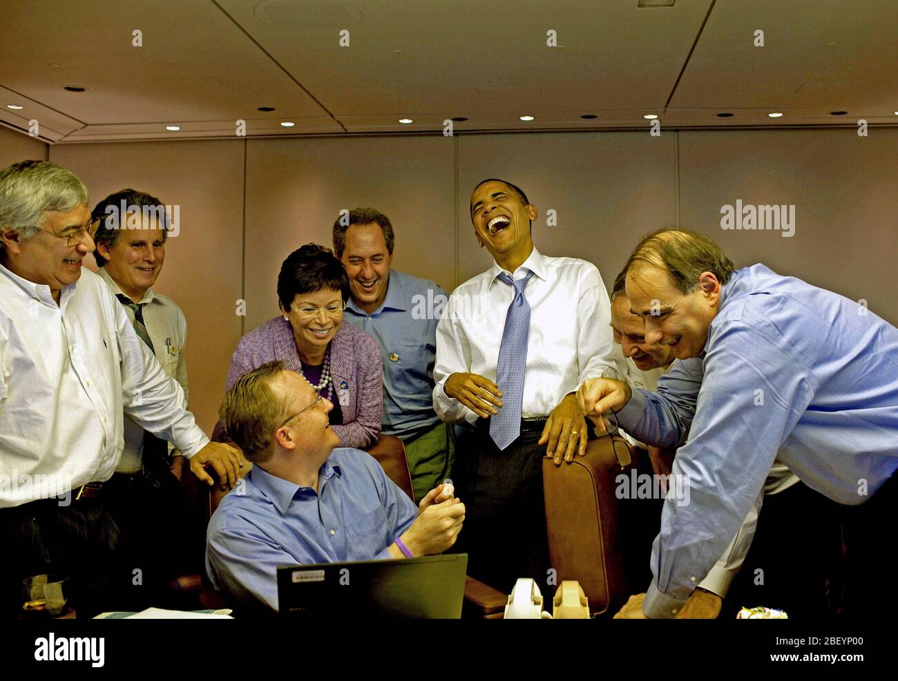 Le président Barack Obama rit des aides à bord d'Air Force One en route vers Singapour, le 14 novembre 2009. Banque D'Images