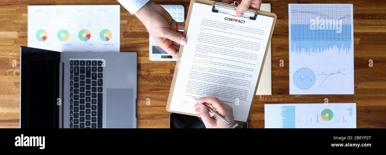 Les hommes signent un contrat sur les périphériques de documents d'arrière-plan Banque D'Images