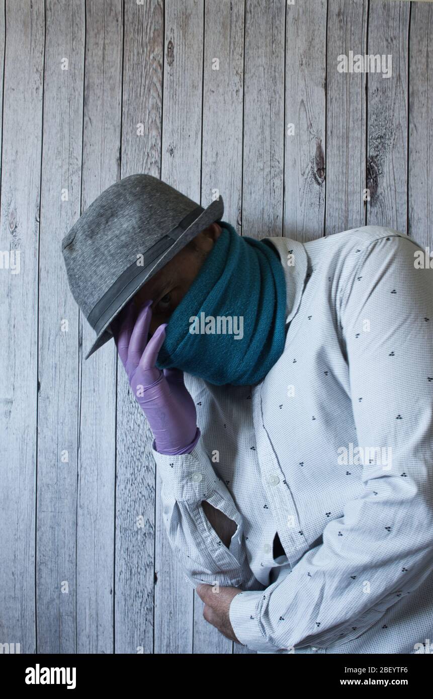 Autoportrait de l'homme avec masque/foulard et chapeau avec divers gestes et poses Banque D'Images