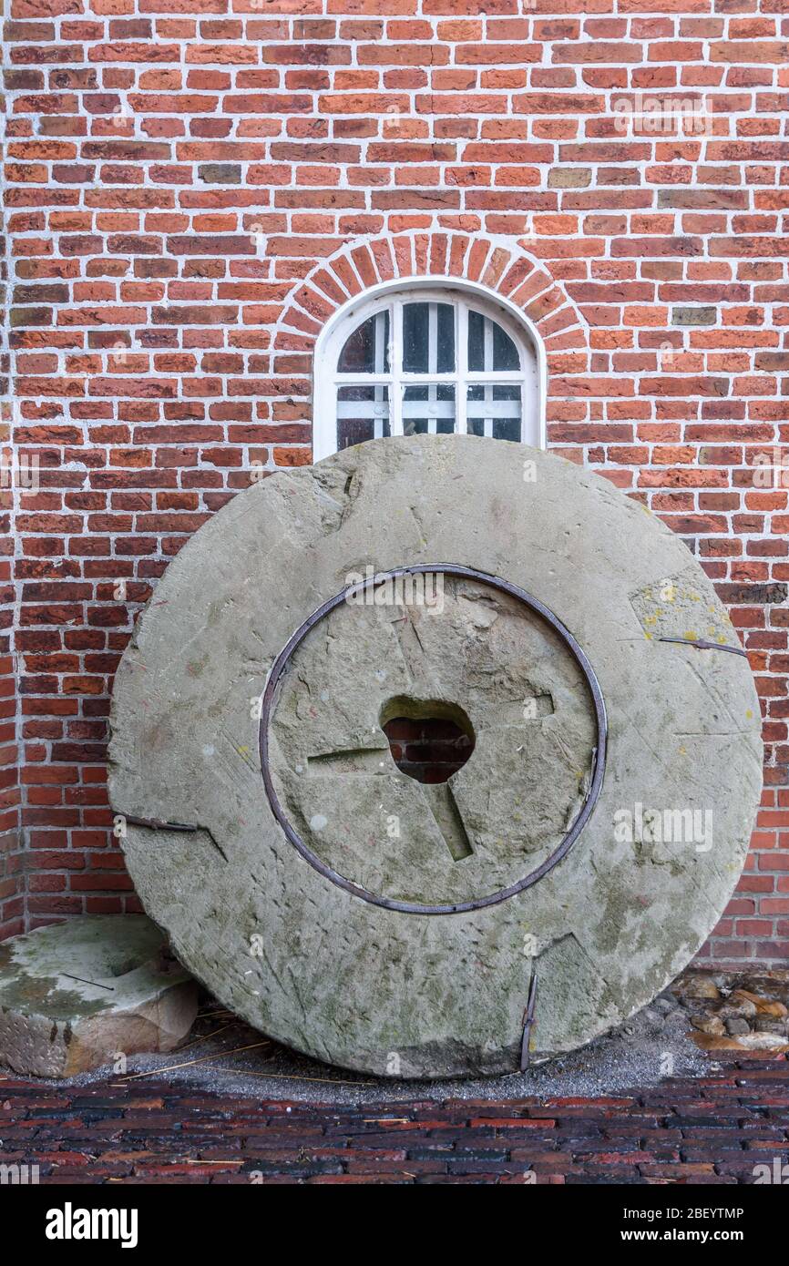 Ancienne pierre de moulin penchée contre un mur, Jemgum Mill, Frise orientale, Basse-Saxe, Allemagne Banque D'Images