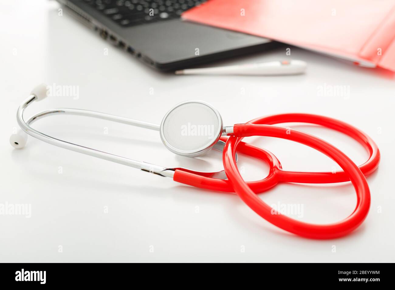 Rendez-vous avec un médecin. Thermomètre, stéthoscope rouge et documents médicaux sur le lieu de travail des médecins au bureau de la clinique. Concept médecine soins de santé Banque D'Images