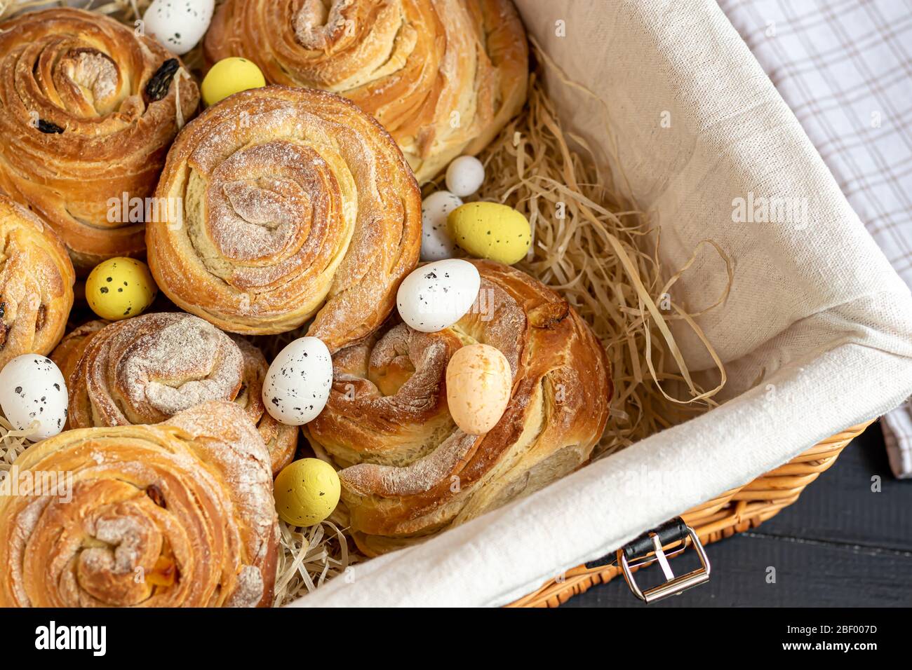 Les produits de boulangerie avec raisins secs et fruits secs sont situés sur un fond en bois sombre. Saupoudrés de sucre glace. Kraffins. Cuisine de Pâques. Espace de copie Banque D'Images