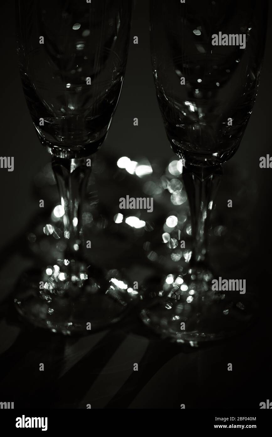 Verres à champagne en cristal illuminés dans une chambre sombre. Concept : minimalisme artistique. Banque D'Images