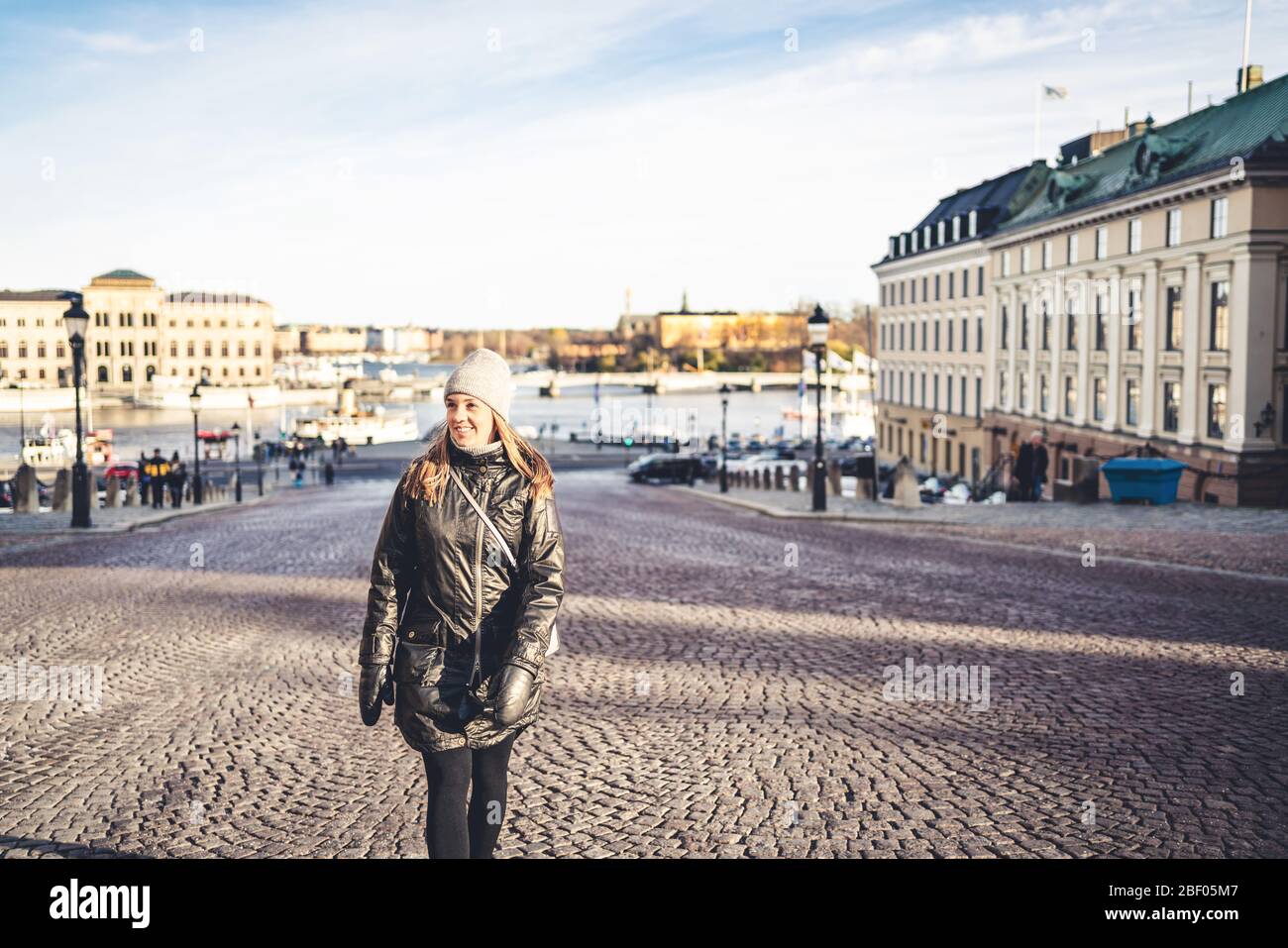 Stockholm en hiver. Personne marchant dans la rue urbaine de Suède. Un touriste heureux regardant les bâtiments de la vieille ville. Femme à Gamla Stan. Banque D'Images