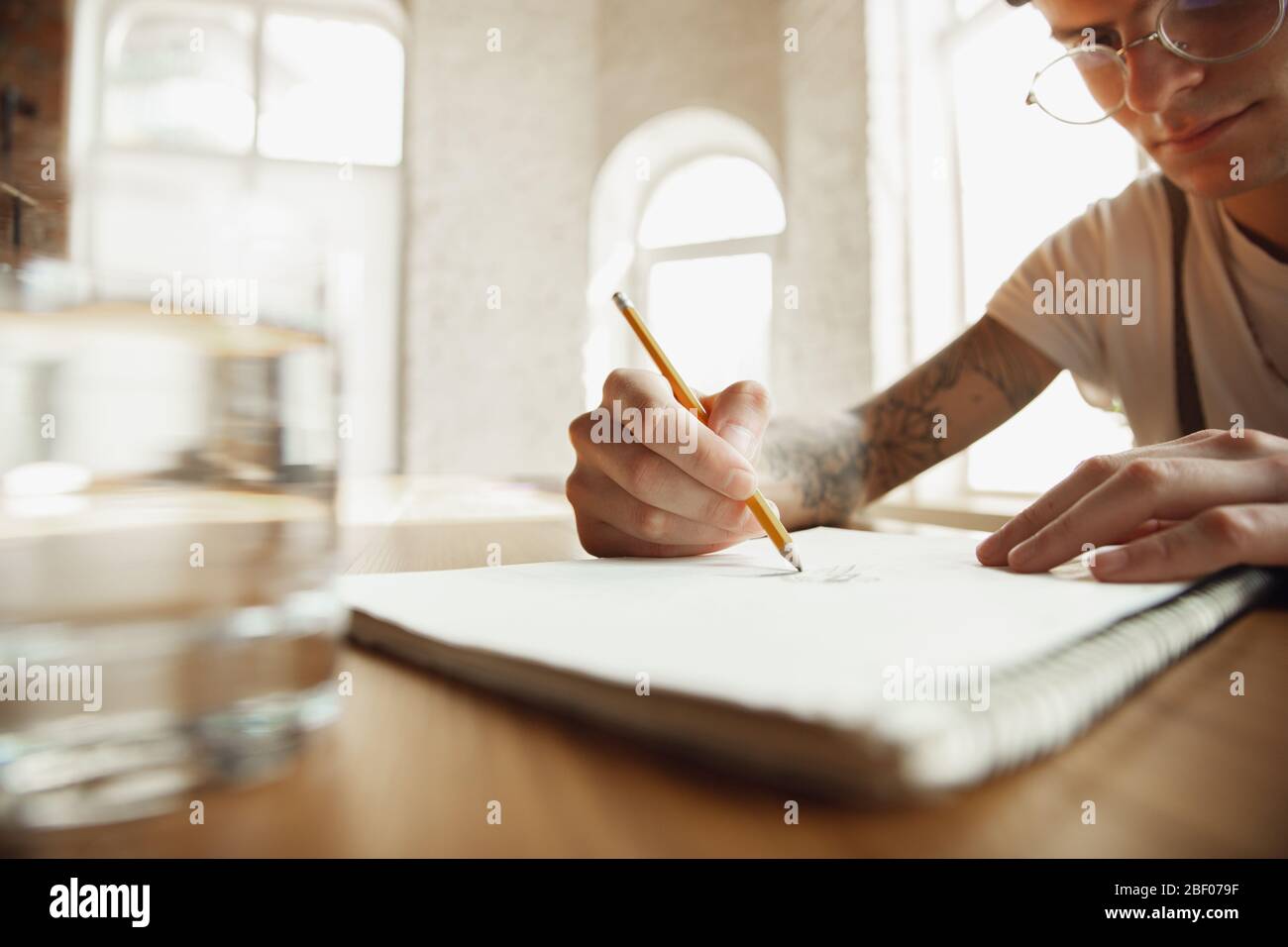 Gros plan sur les mains des hommes écrivant sur un papier vide sur la table à la maison. Prendre des notes, travailler à domicile, faire rapport pour son travail. Éducation, freelance, art et concept d'affaires. Laisse la signature, faisant des documents administratifs. Banque D'Images