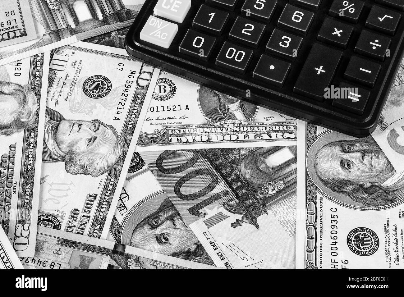Contexte avec argent dollars américains et billets d'euros et calculatrice noire. Argent comptant. Image en noir et blanc. Banque D'Images