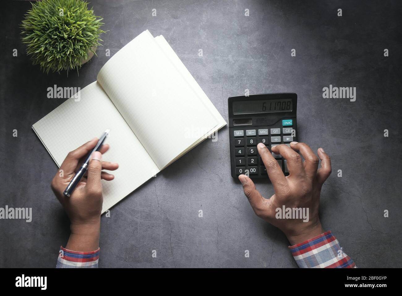 comptable utilisant la calculatrice et le tableau financier Banque D'Images