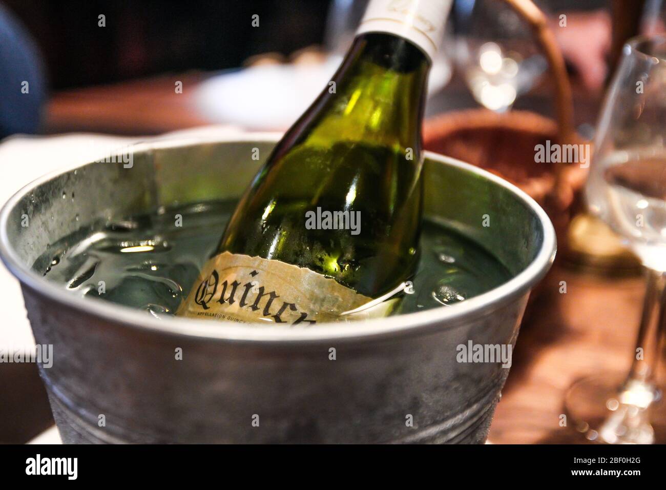Bouteille de vin blanc en verre dans un seau rempli de glace et d'eau pour le garder frais. Restaurant à Honfleur, Normandie, France. Juin 2019. Banque D'Images