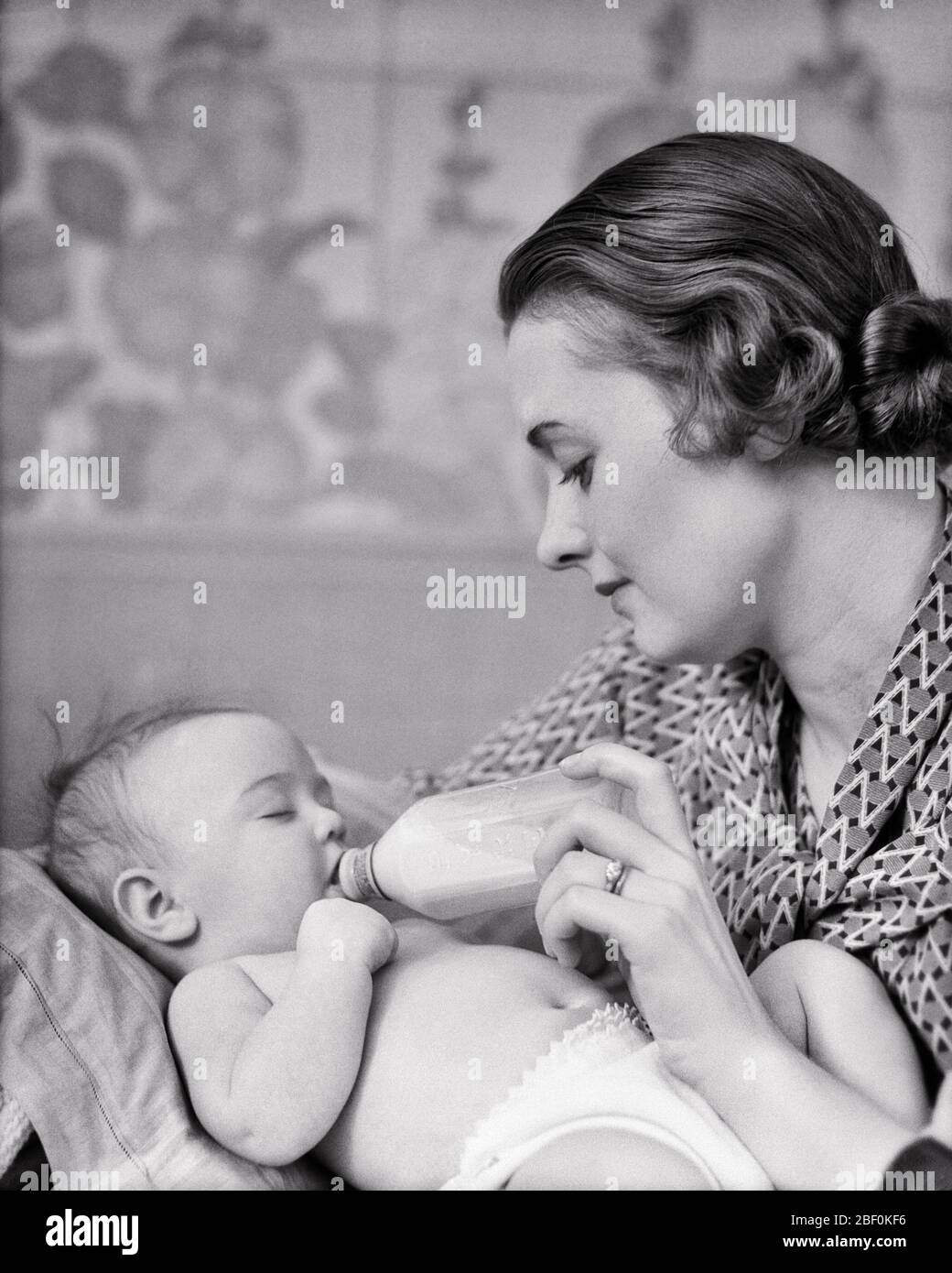 Annees 1930 1940 Femme Brunette Mere Se Nourrissant Contenant Du Lait En Verre Bouteille Pour Bebe Endormi Fille Fille En Pepiniere 27 Har001 Hars Vieille Epoque Nostalgie Ancienne Mode 1 Nourrir