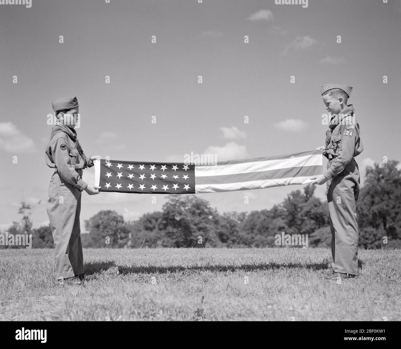 ANNÉES 1950 DEUX JEUNES SENTEURS EN UNIFORME REPLIANT UN DRAPEAU AMÉRICAIN 48 ÉTOILES - B6113 HAR001 HARS B&W LIBERTÉ GAI LEADERSHIP ORGUEIL LES UNIFORMES FRÈRES GARÇON CONNEXION SCOUT THRIFTY CONCEPTUEL COURTOIS AIMABLE GENTIL SERVIABLE VÉNÉRÉ COOPÉRATION DIGNE DE CONFIANCE JEUNES FIDÈLES PRÉ-ADOLESCENTS JEUNE ROUGE ET BLEU ÉTOILES ET BANDES L'UNITÉ DOIT ÊTRE PRÉPARÉE EN NOIR ET BLANC BRAVE RACE CAUCASIENNE HAR001 OBÉISSANT À L'ANCIENNE Banque D'Images