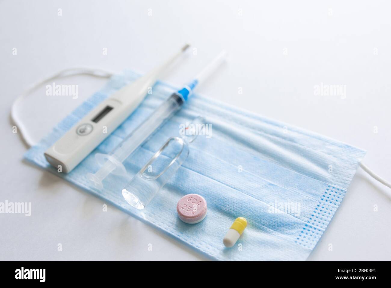 masque médical sur fond cyan, bleu.masque de visage. masque pour maladies. Thermomètre et médicament. Image faciale jetable. Bandage respiratoire médical visage. Concept de quarantaine du coronavirus. Banque D'Images