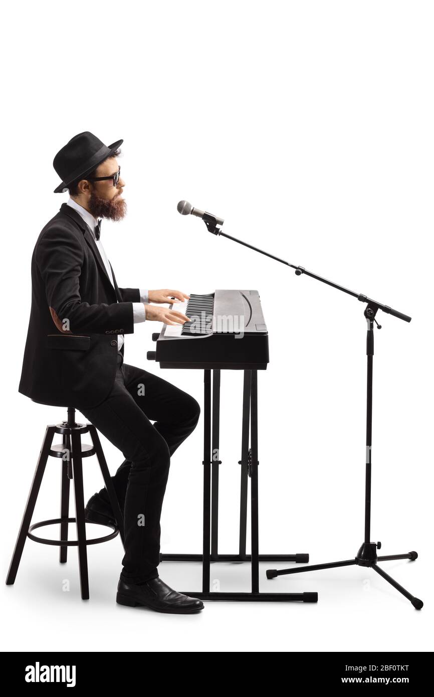 Artiste jouant un piano numérique et chantant sur un microphone isolé sur fond blanc Banque D'Images
