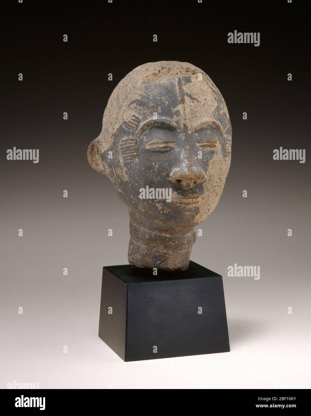 Tête commémorative. Cette tête en terre cuite a commémoré un membre d'une famille royale qui vivait dans ce qui est maintenant au centre sud du Ghana. Ces sculptures, considérées comme des substituts pour le défunt, ont été installées lors de funérailles formelles, qui ont eu lieu des jours ou des mois après l'enterrement réel. Banque D'Images