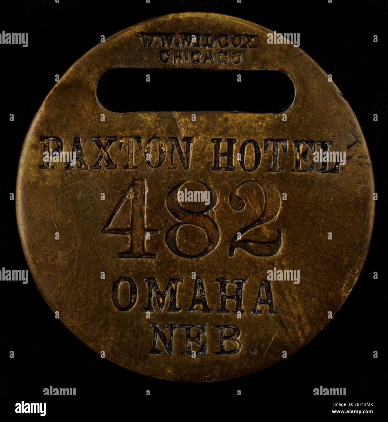 Paxton Hotel Owney tag. Cette étiquette ronde en métal et laiton marque la visite d’Owney à l’hôtel Paxton à Omaha, Nebraska. L'hôtel a été nommé pour un homme d'affaires local de premier plan, William A. Paxton (1837-1907). Il n'y a pas d'information disponible pour indiquer quand cette balise a été présentée à Owney. Banque D'Images