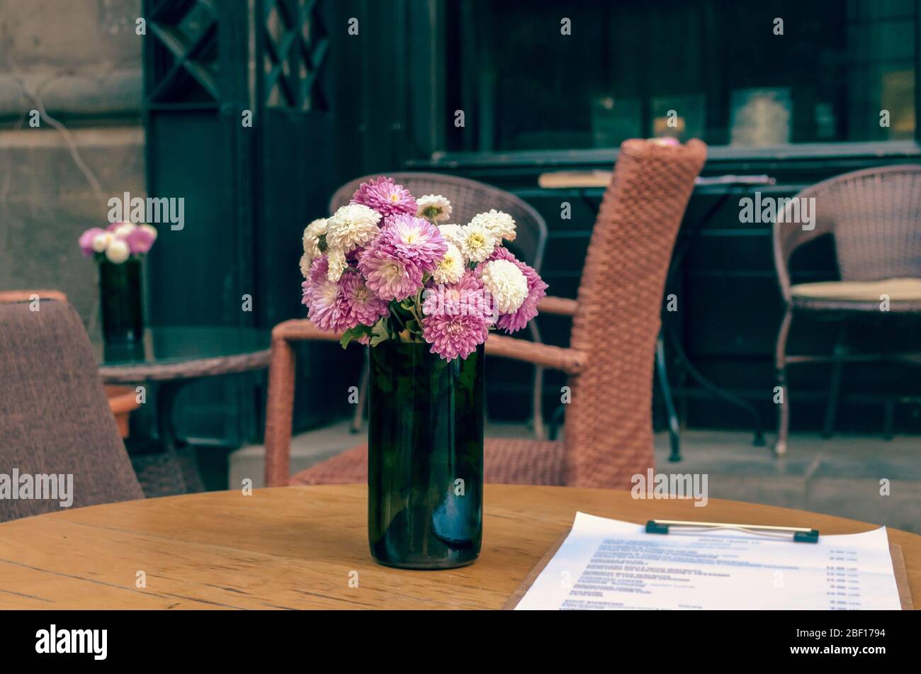 Café de rue vide avec menu et bouquets de chrysanthèmes sur des tables à Tbilissi Géorgie Banque D'Images