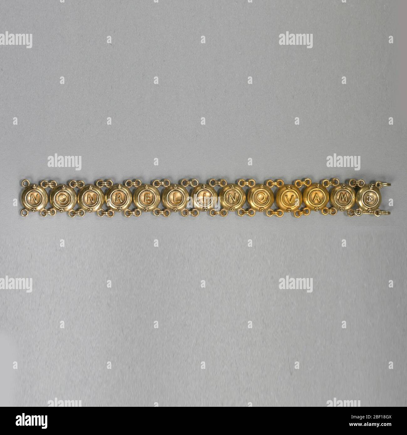 Bracelet les mots latins NONRELINQUES d'un côté NONRELINQUAM de l'autre. Bracelet de treize disques liés avec des lettres orthographiées 'NONRELINQUES' d'un côté, et 'NONRELINQUAM' de l'autre. Banque D'Images