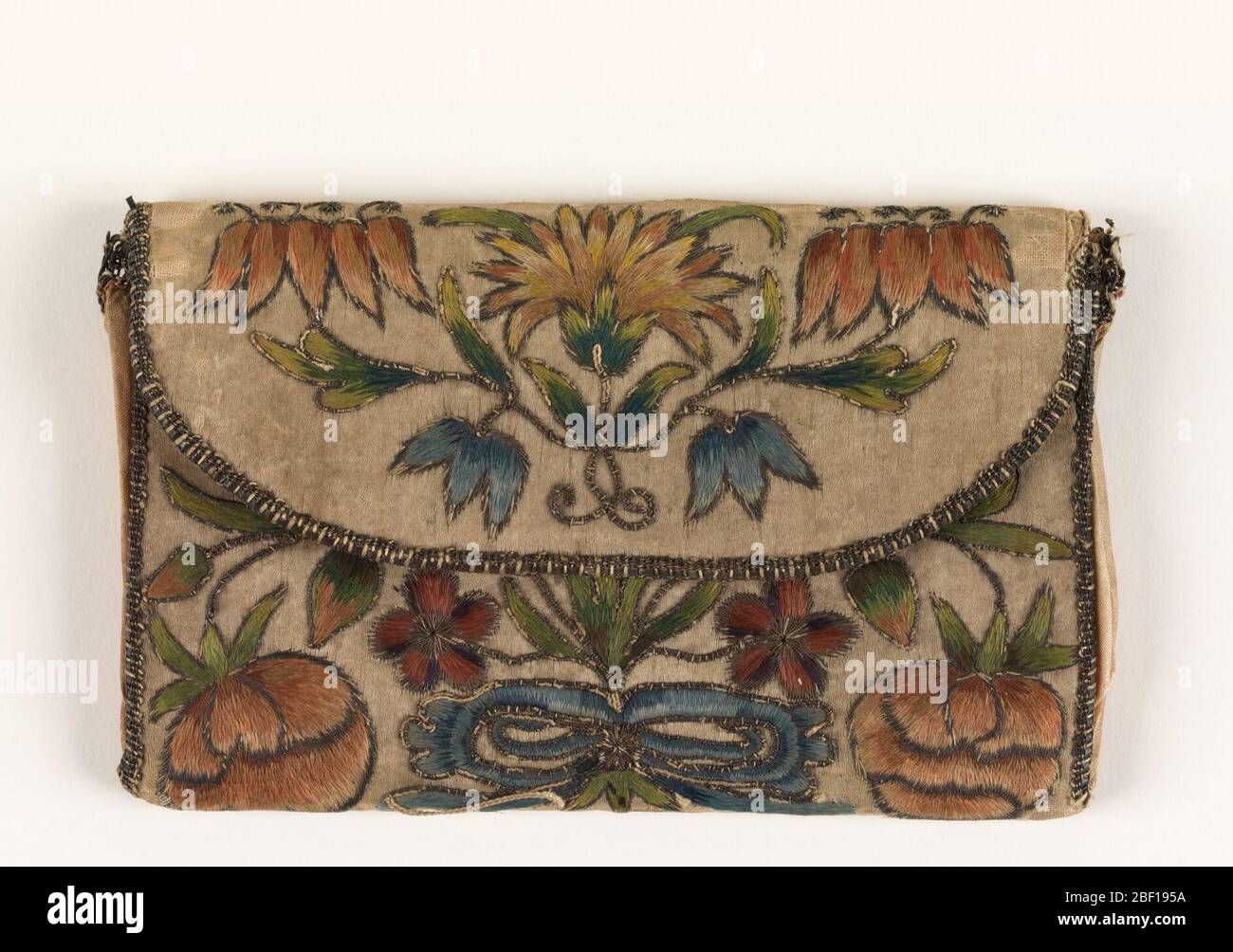 Lettre. Lettre en satin ivoire brodée avec fleurs en soie polychrome et fils métalliques, taillée avec dentelle de bobine métallique. Banque D'Images