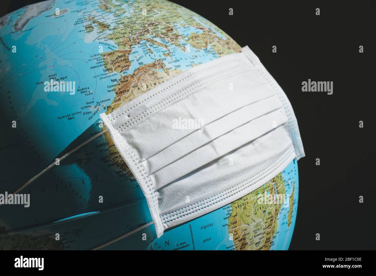 Globe avec masque médical blanc. Coronavirus, concept COVID-19. Expression du verrouillage et de la quarantaine dans le monde entier en raison du virus 2019-ncov. Planète Terre en pandémie. Restrictions de voyage. Banque D'Images