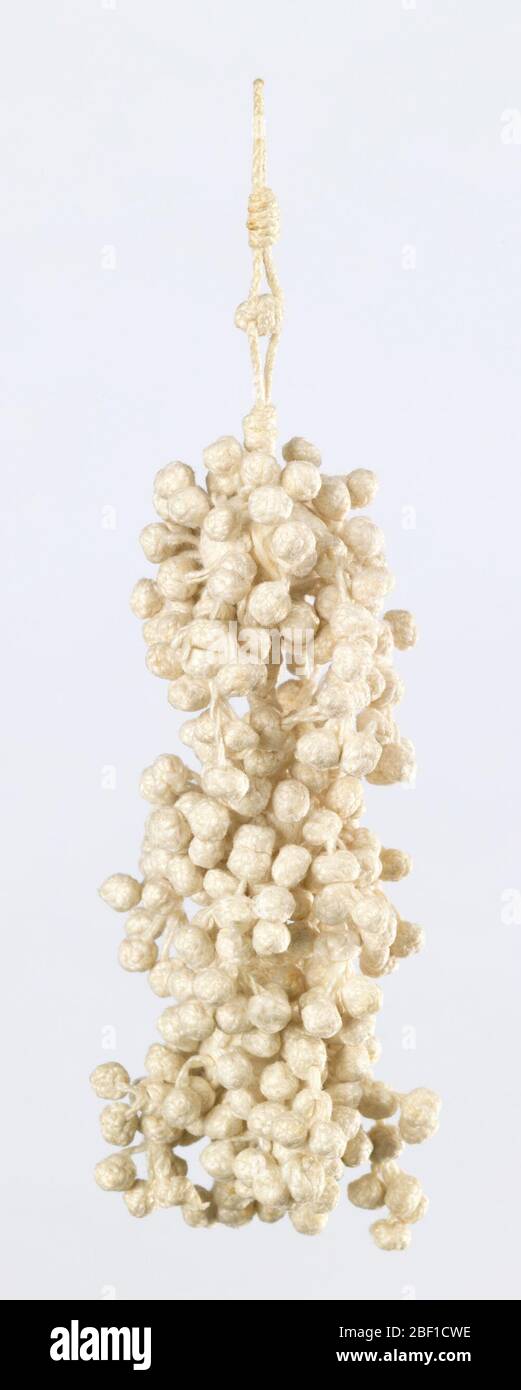 Pampille. Pampille en lin blanc avec trois boules reliées l'une à l'autre par une tige tressée pour créer une base à trois niveaux. Les trois balles sont recouvertes de petites boules nouées. Banque D'Images