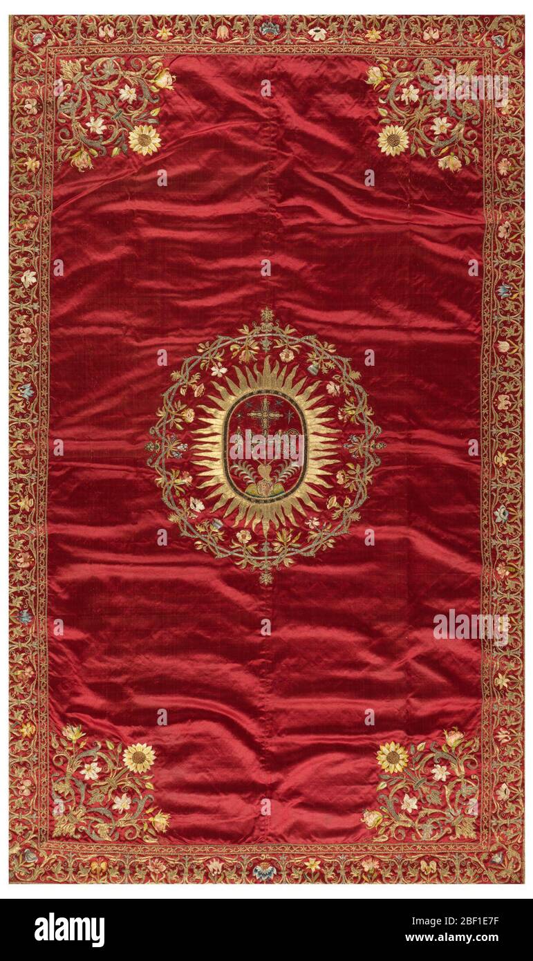 Pendante. Pendaison de soie rouge foncé brodée sur tous les côtés avec bordure montrant un motif fleuri en fils métalliques et soie multicolore. Le centre montre un soleil de forme ovale rempli d'un coeur percé et d'autres dispositifs symboliques. Banque D'Images