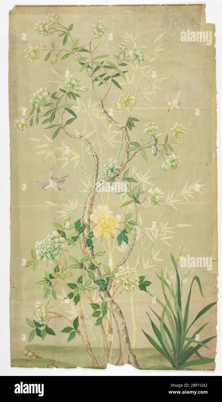 Pittoresque. Imprimé sur un fond vert pâle. Masse verte plus foncée en bas. Arbre fleuri avec fleurs blanches, et grande plante pivoine avec fleurs blanches et jaunes pâle. Arbres en bambou en arrière-plan. Oiseaux blancs volants. Banque D'Images