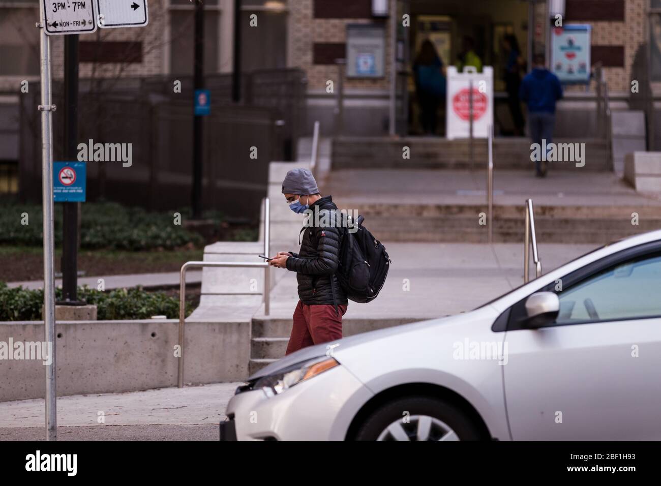 CENTRE-VILLE DE VANCOUVER, C.-B., CANADA - APR 01, 2020 : personne portant un masque facial médical à l'extérieur de l'hôpital St Pauls de Vancouver pendant la pandémie de Covid 19. Banque D'Images