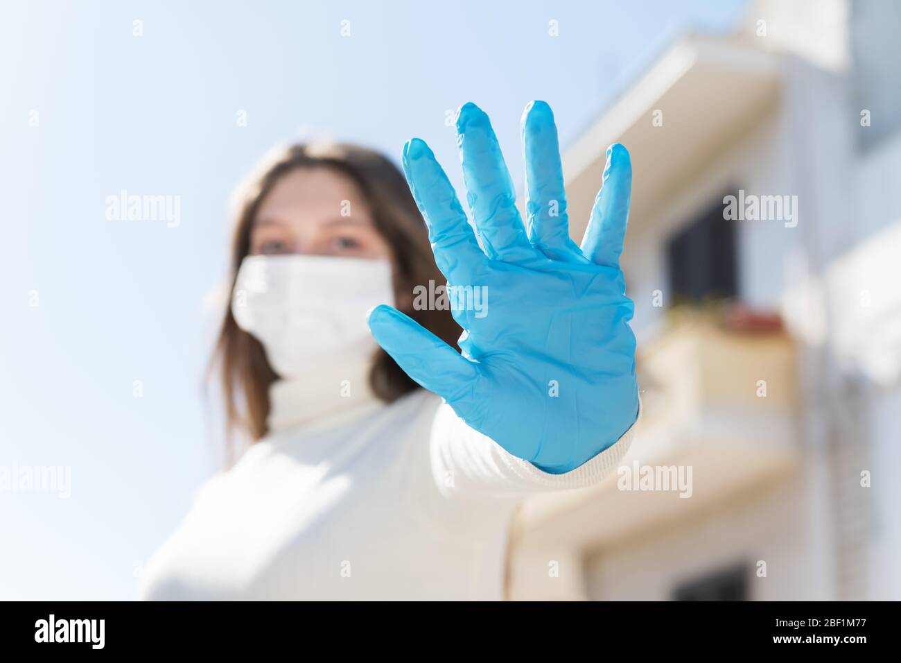 Restez à la maison. Quarantaine de Covid-19. Une fille dans un masque de protection et des gants bloque le virus Corona. Distance sociale Banque D'Images