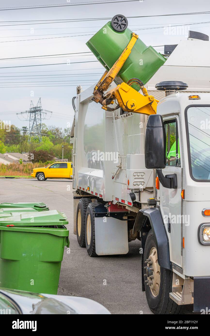 Tir vertical d'un camion à ordures avec un bras de robot qui décharge les  déchets d'une poubelle en plastique vert résidentiel Photo Stock - Alamy