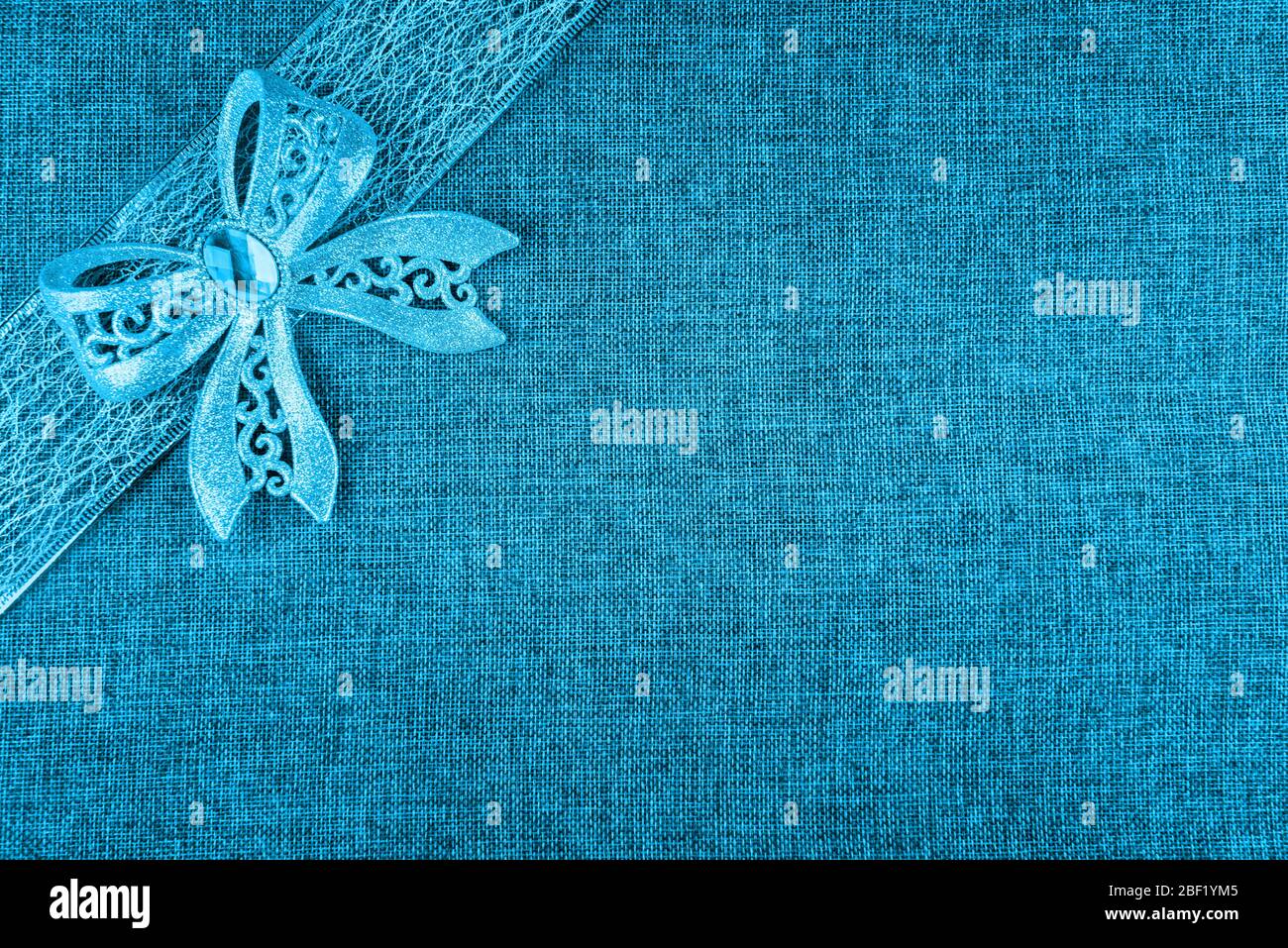 Élégant noeud brillant bleu brillant sur ruban bleu et sur toile bleu. Fond de carte de vœux horizontal avec grand espace de copie et maïs décoré Banque D'Images