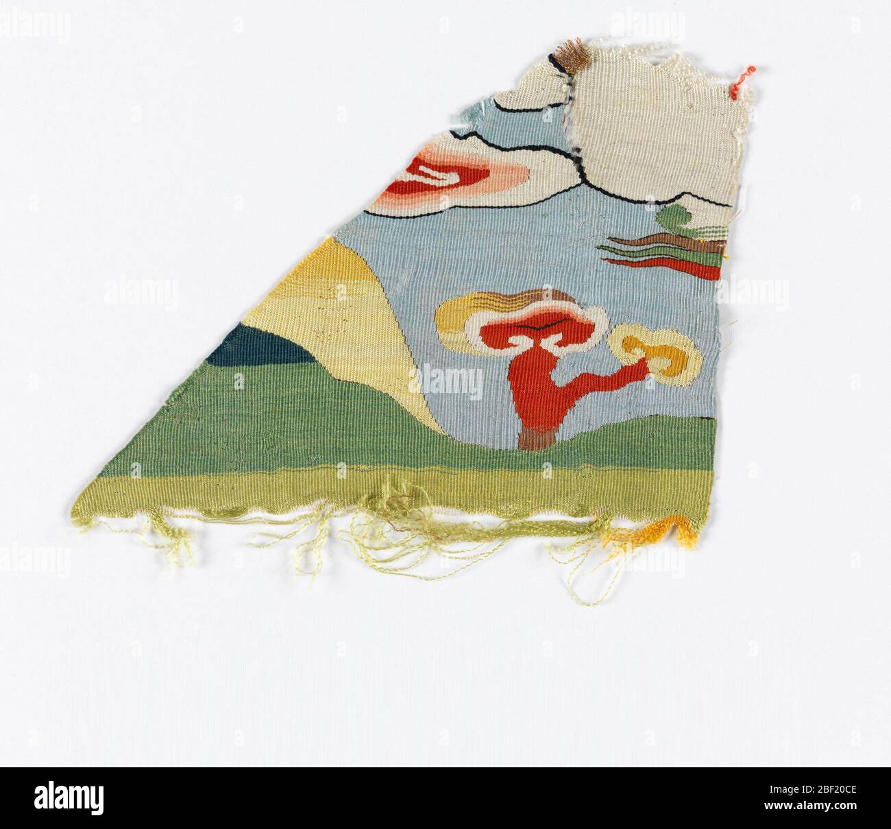 Fragment d'un badge de rang. Fragment d'un badge de rang. Image partielle d'un ciel bleu avec nuages blancs et roses, avec sol vert, coucher de soleil jaune et arbre rouge. Banque D'Images