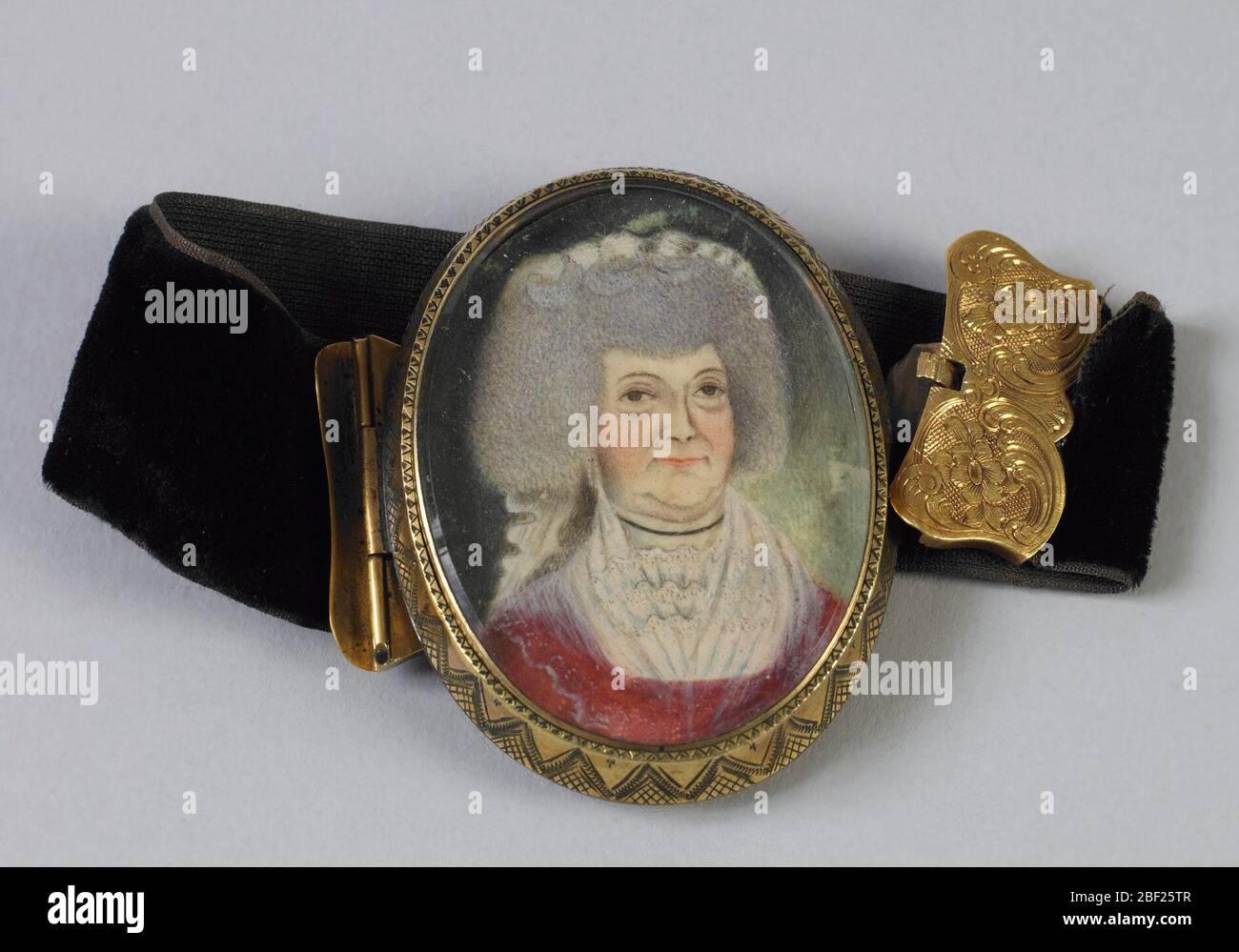 Jeu miniature portrait sur bracelet. Portrait ovale miniature d'une femme portant une robe rouge, CA. 1790, derrière le verre et enfermé dans un cadre doré; placé dans un bracelet en velours noir avec des clamps dorés, ca. 1830. Banque D'Images