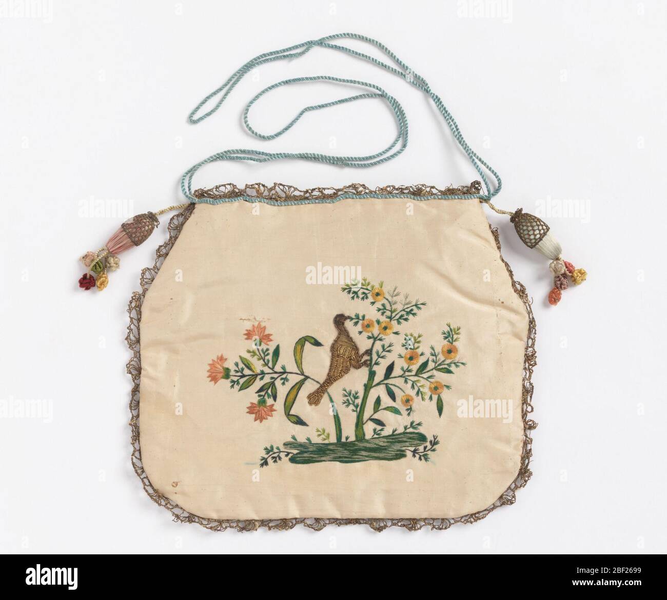 Sac à main. Sac plat en taffeta de soie blanche, brodés des deux côtés avec des cigoles de couleur et des fils métalliques; avant, panier de fleurs; dos, spray de fleur avec oiseau. Orné de dentelle dorée étroite. Cordon en soie bleue sur le dessus ; glands couverts aux coins. Banque D'Images