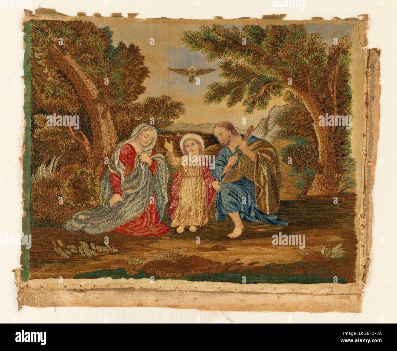 Photo brodée. La Sainte famille (Marie, Jésus et Joseph) dans un paysage avec l'Esprit Saint, personnifiée comme une colombe, dans le ciel. Le tissu en soie a été placé sur un tissu en lin tissé Uni et la broderie a été faite à travers les deux couches. Banque D'Images