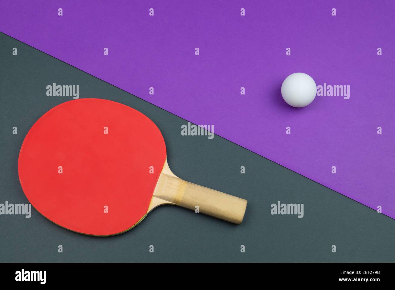 Raquette de tennis de table rouge avec une balle isolée sur un fond coloré. Équipement de sport pour ping-pong. Espace de copie Banque D'Images