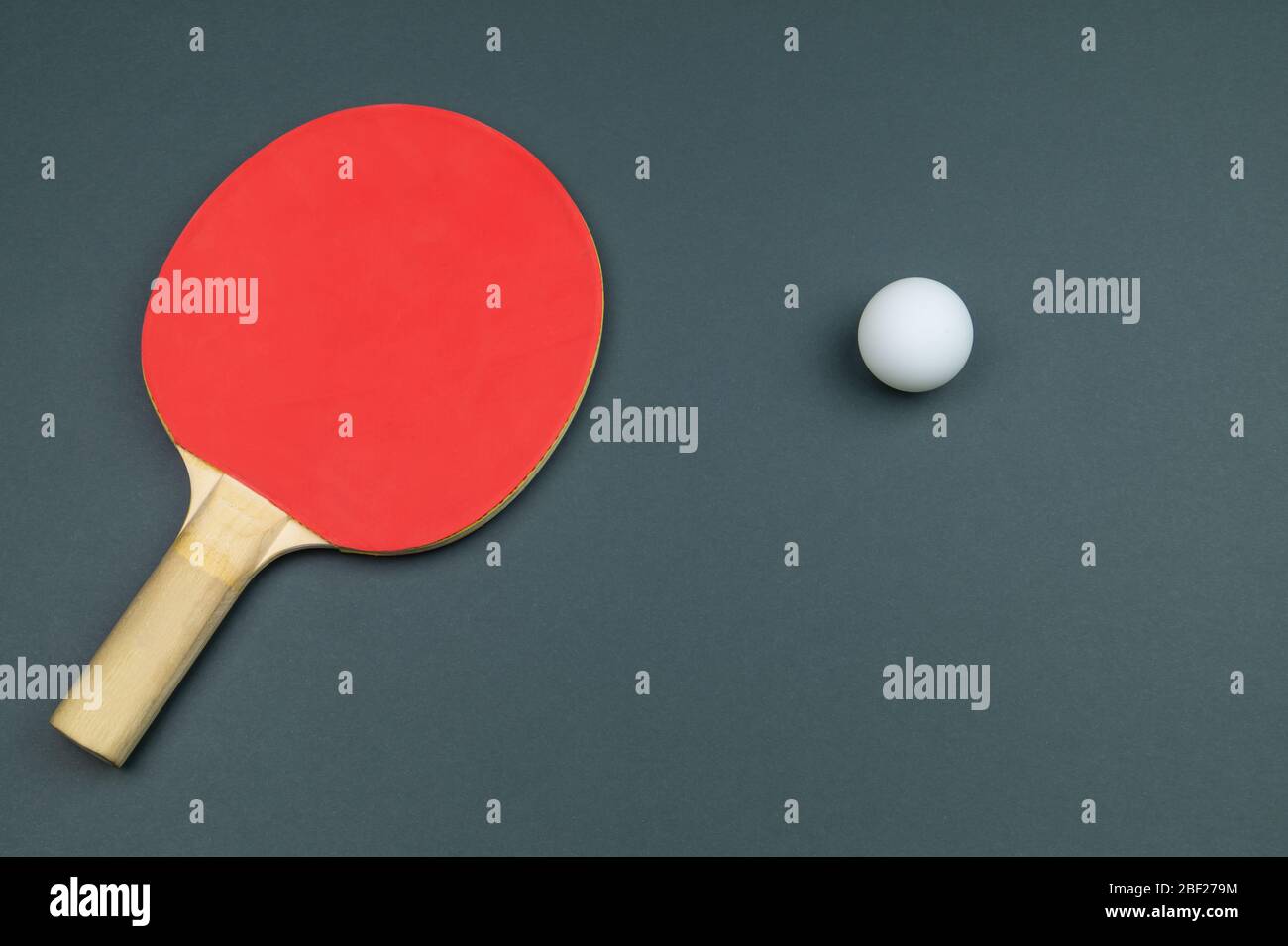 Raquette de tennis de table rouge avec une balle isolée sur un fond coloré. Équipement de sport pour ping-pong. Espace de copie Banque D'Images