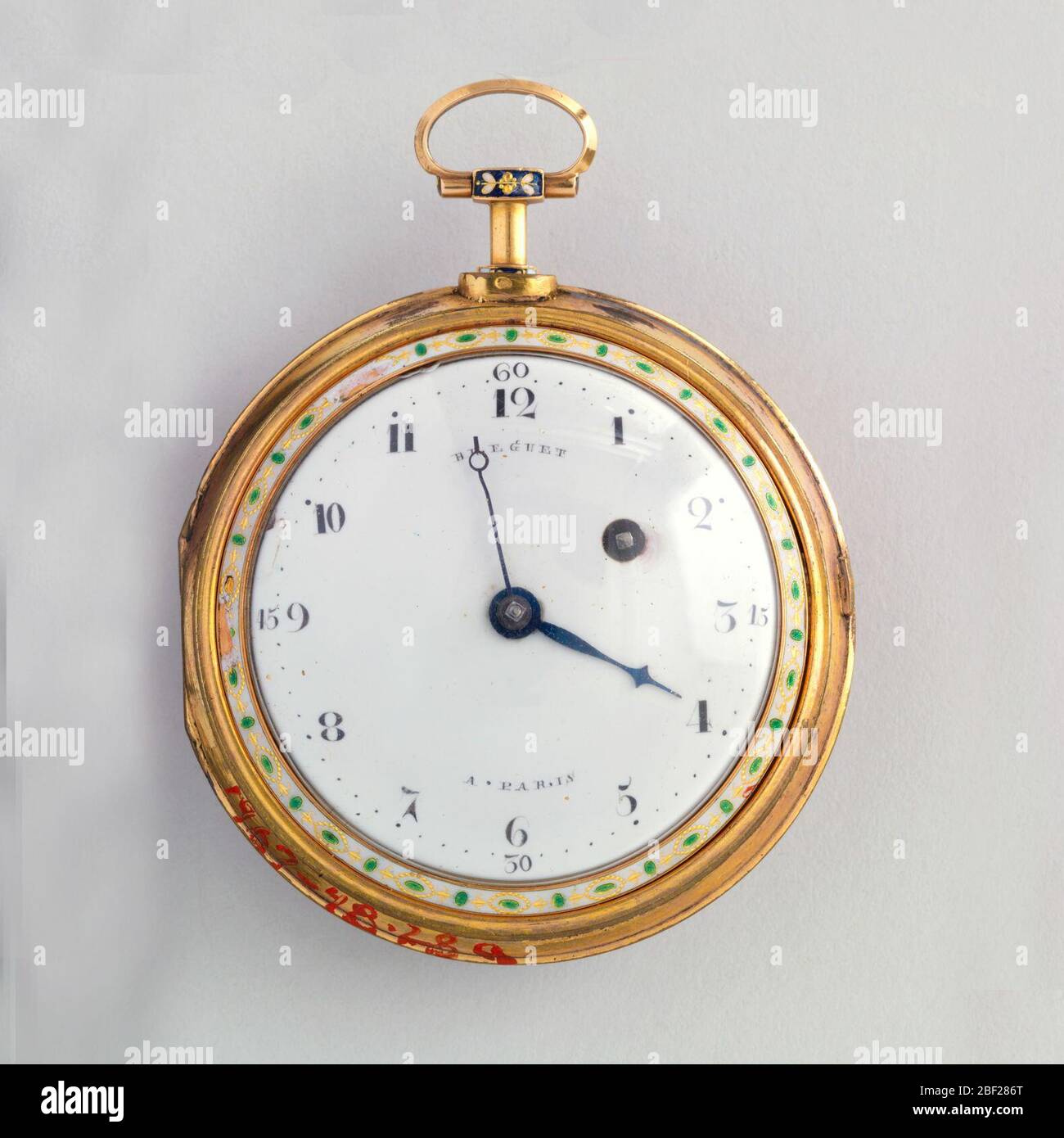 Regarder et chatelaine. Boîtier circulaire en or avec tige avec petit anneau en haut; face avant avec face circulaire blanche avec chiffres romains en acier noir et bleué(?) mains, l'ensemble entouré d'un étroit bracelet émaillé blanc avec dorures et décoration de losange vert. Banque D'Images