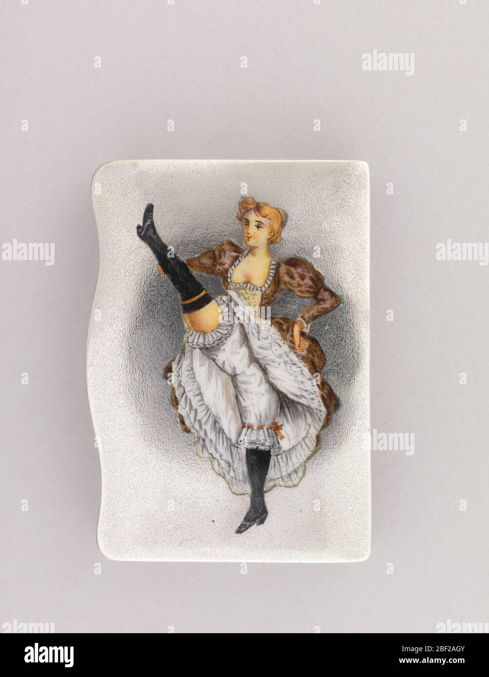 Danseur Cancan. Conteneur rectangulaire à priser, avec image en émail polychrome située verticalement, de danseuse de cancan blonde avec pied droit haut. Banque D'Images