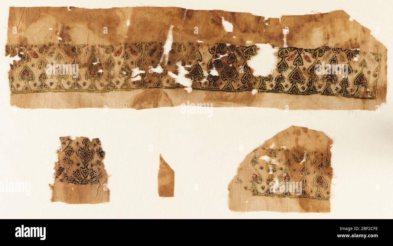 Textile. Tiraz, bande horizontale brodée de motifs de palmette en polychrome. Banque D'Images