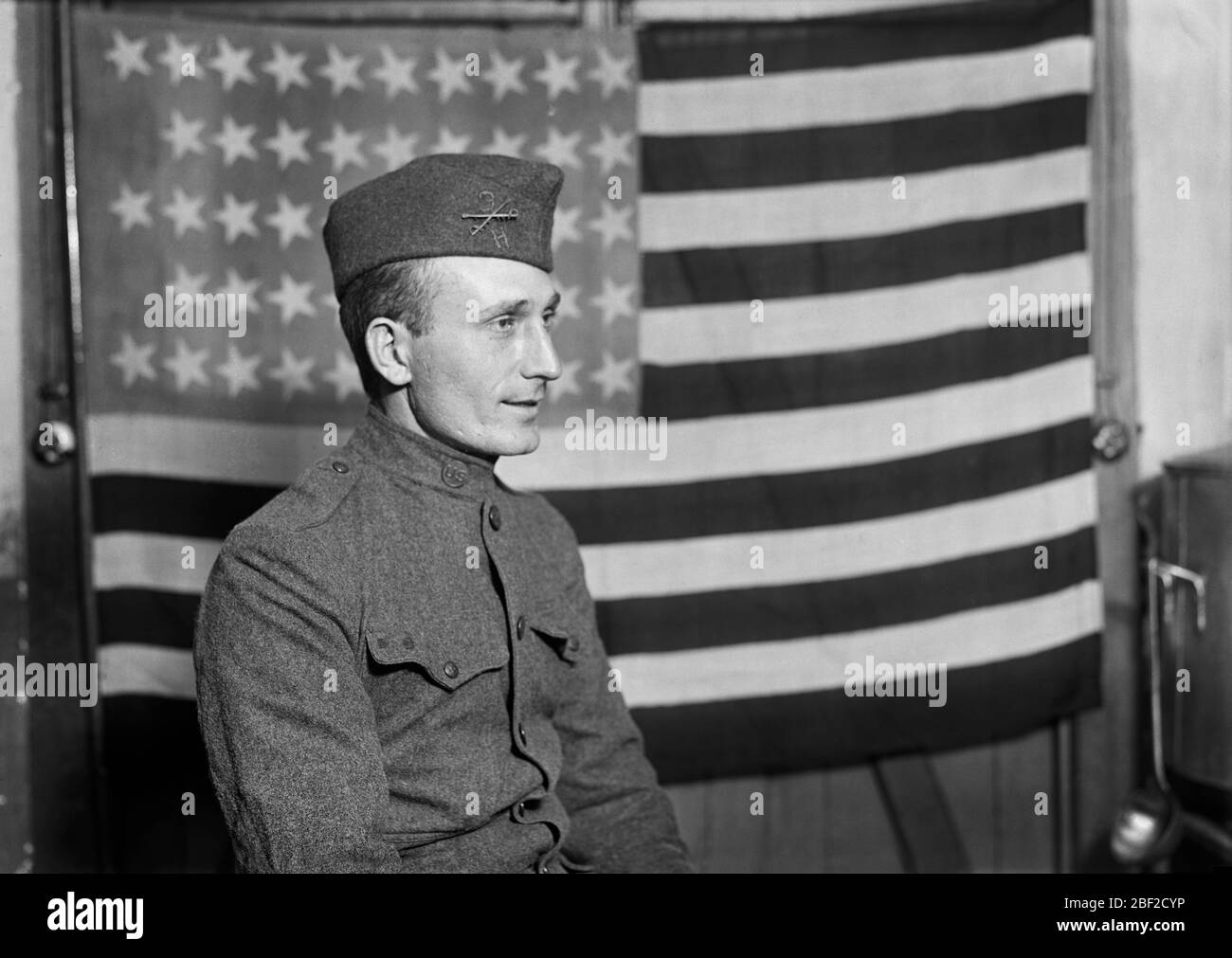 Portrait en demi-longueur du soldat américain avec drapeau américain en arrière-plan, France, Lewis Wickes Hine, Collection de photographies de la Croix-Rouge nationale américaine, octobre 1918 Banque D'Images