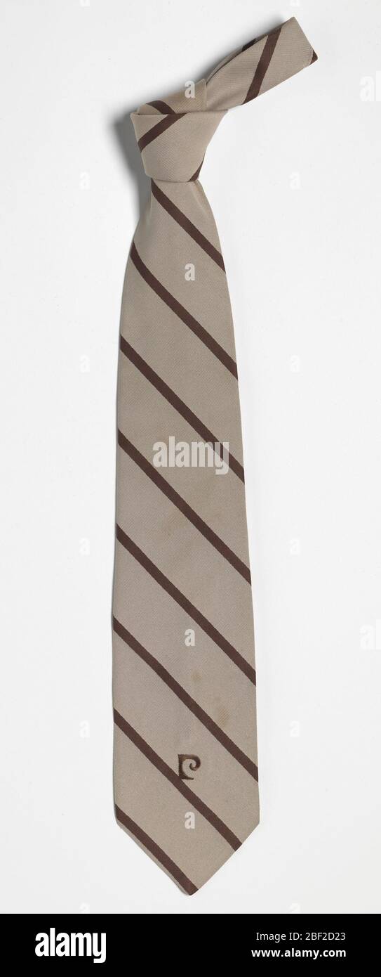 Cravate portée par Ira Tucker. Le cravate à rayures brunes est doublée de tissu de style soie et de tissu tissé blanc épais. Un « P » marron brodé stylisé est présent au bas de la cravate. Banque D'Images
