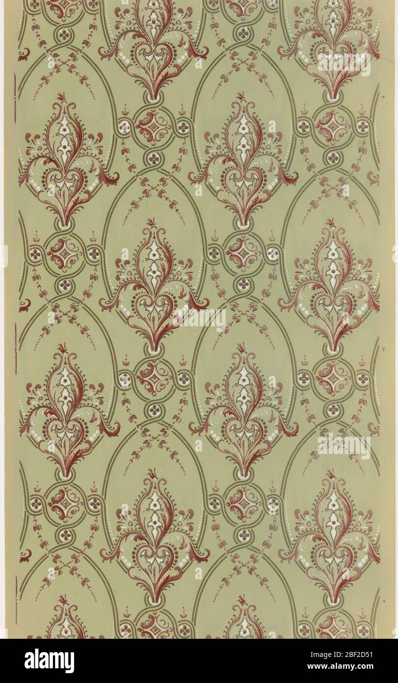 Flanc. Motif fleuri stylisé ressemblant à une fleur de lis dans un cadre ovale. Un ensemble de cercles verrouillés, un grand avec quatre petits, relie les cadres ovales. Imprimé en rouge foncé, blanc et marron sur un sol vert. Banque D'Images